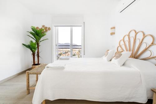 ein weißes Schlafzimmer mit einem großen Bett und einem Fenster in der Unterkunft Apartamento WELCS EMP - 101 con vistas al Mar in Empuriabrava