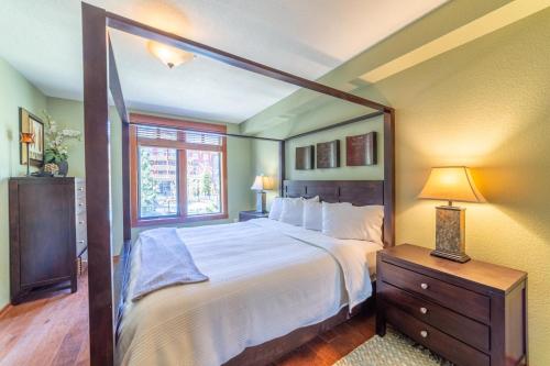 a bedroom with a large bed and a window at 506 Village Condo Steps to Gondola in Mammoth Lakes
