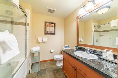uma casa de banho com um lavatório, um chuveiro e um WC. em 506 Village Condo Steps to Gondola em Mammoth Lakes