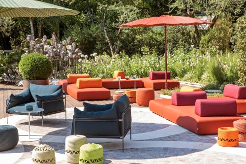 a group of chairs and umbrellas in a garden at L'Albereta Relais & Chateaux in Erbusco