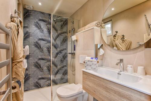 a bathroom with a toilet and a sink and a shower at Le Castel Cabourg hôtel & SPA- Restaurant La Calypso in Cabourg