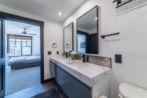 a bathroom with a sink and a mirror and a bed at #544- Luxury Village 3BR - Spa, Pool, & Walk to Gondola in Mammoth Lakes