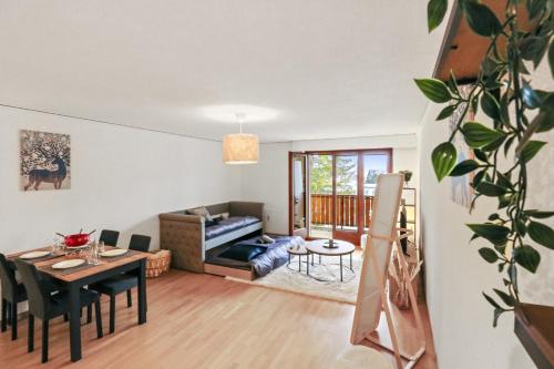 un soggiorno con un tavolo e un divano di Charmant appartement au centre a Crans-Montana