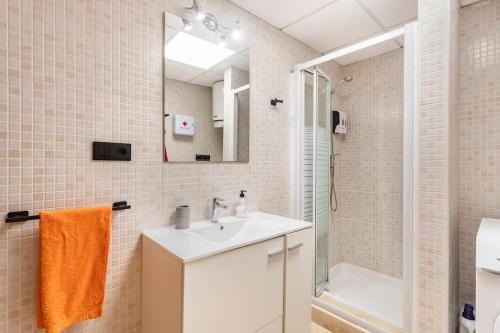 ein Badezimmer mit einem weißen Waschbecken und einer Dusche in der Unterkunft CastelPlace beach con plaza de Garage incluida, free parking in Alicante