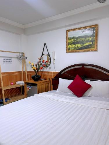 大叻的住宿－Khách Sạn Ngọc Khánh，卧室配有白色的床和红色枕头