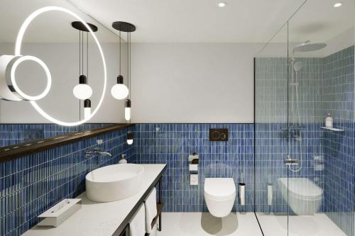 uma casa de banho com um lavatório, um WC e um espelho. em The Yarn em Horgen