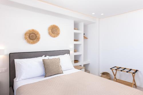 Caval Residences في Falatádhos: غرفة نوم بيضاء بسرير وجدران بيضاء