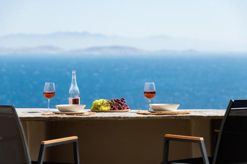 a table with two glasses of wine and a plate of fruit at Caval Residences in Falatádhos
