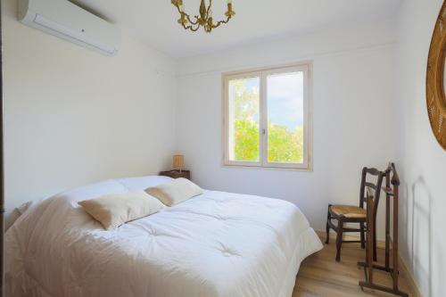 - un lit blanc dans une chambre avec fenêtre dans l'établissement Maison familiale Kerriou, à Plestin-les-Grèves