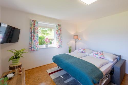 Schlafzimmer mit einem Bett und einem Fenster in der Unterkunft Appartement Annis Murtalblick in Sankt Margarethen im Lungau