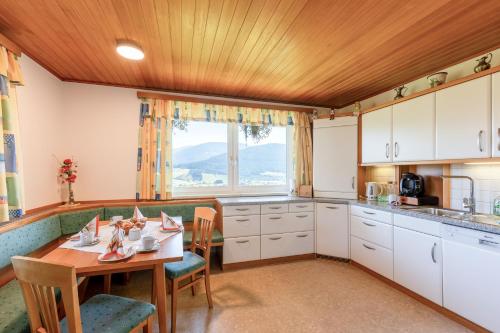 eine Küche mit einem Tisch und Stühlen sowie einem Fenster in der Unterkunft Appartement Annis Murtalblick in Sankt Margarethen im Lungau