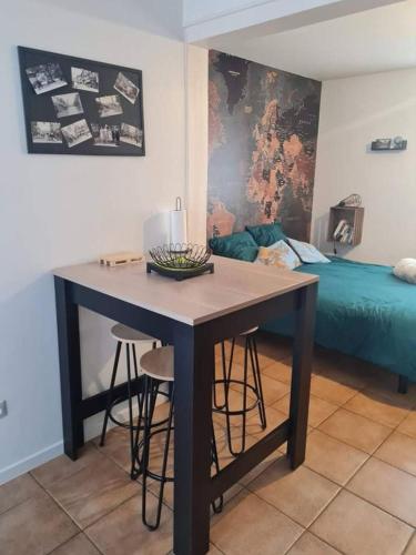 Cette chambre comprend une table avec tabourets et un lit. dans l'établissement Little World - Saint-Julien-les-villas, à Saint-Julien-les-Villas