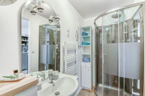 un bagno bianco con doccia e lavandino di Little World - Saint-Julien-les-villas a Saint-Julien-les-Villas
