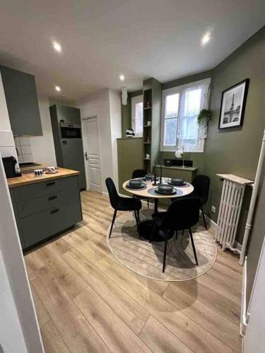 une cuisine avec une table et des chaises dans une pièce dans l'établissement Le Saint-Mandé Élégant et Pratique, Métro 1 à Deux Pas, à Saint-Mandé