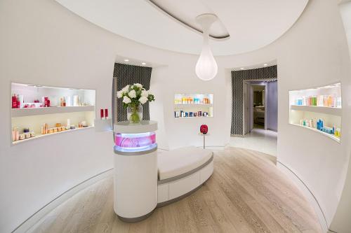 a white room with a vase of flowers at Hôtel de Paris Saint-Tropez in Saint-Tropez