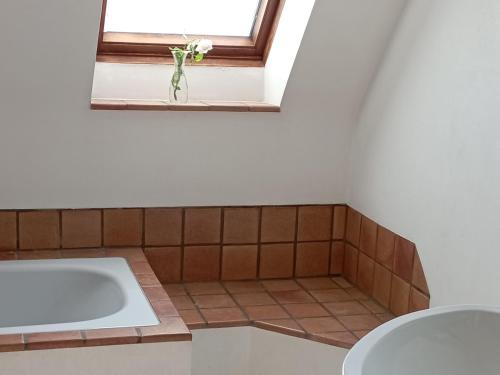 ein Bad mit einer Badewanne und einem Fenster in der Unterkunft Haus Scheibenhardt 