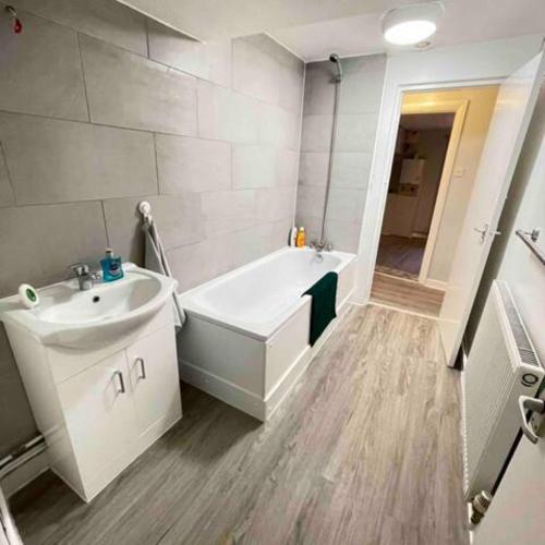 a bathroom with a white tub and a sink at London Apartment - Near Kings Cross St Pancreas! in London