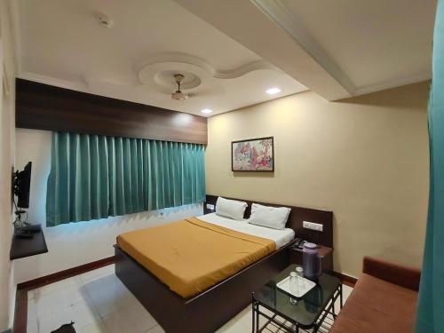 1 dormitorio con 1 cama y cortina verde en HOTEL PANETAR PALACE, en Ahmedabad