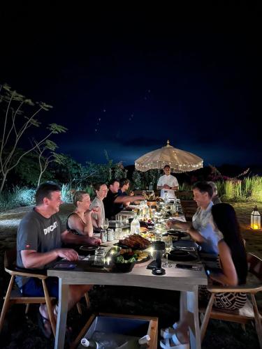 a group of people sitting at a long table at night at Lobster Bay Lombok in Awang