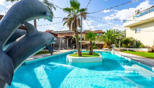a dolphin statue in the water in a swimming pool at Checkin Camino de Granada in Granada