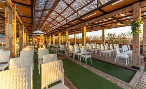 a row of white chairs on a deck with grass at Checkin Camino de Granada in Granada