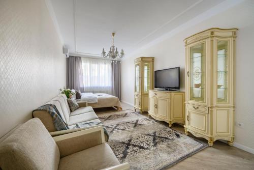 sala de estar con sofá y TV en КАК Дома - квартира на 6 человек, en Almaty