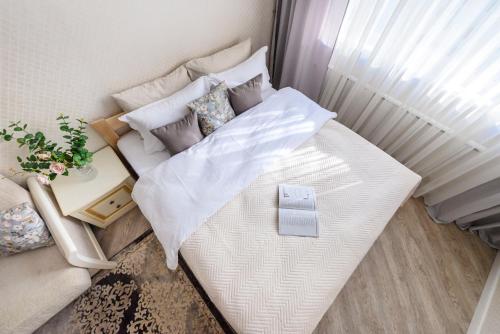 Cama blanca grande en habitación con mesa en КАК Дома - квартира на 6 человек, en Almaty