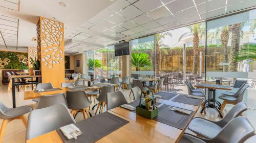 a restaurant with tables and chairs and windows at Checkin Camino de Granada in Granada