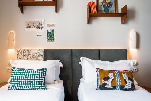 two beds in a room with two pillows at Kraft Hotel in Paris