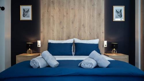 a bedroom with a blue bed with blue sheets and pillows at ORIENTE SUITE APARTMENT in Kalabaka
