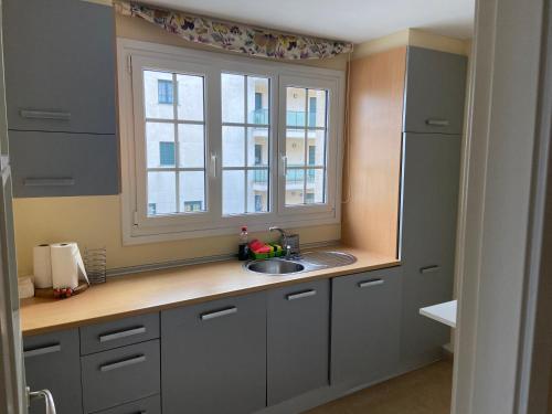 cocina con fregadero y ventana en apartamentos beach langosteira 2 en Finisterre