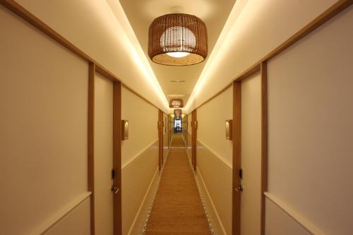 a long corridor with a ceiling with a light fixture at Hostal Empúries in L'Escala