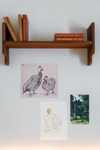 a shelf with two drawings of a bird and books at Kraft Hotel in Paris