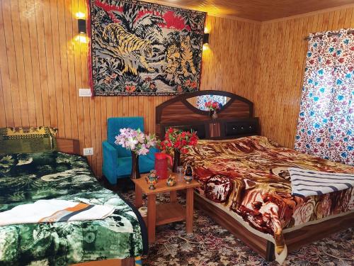 H.B Holiday home في سريناغار: غرفة نوم بسريرين وطاولة مع ورد