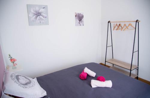 a bedroom with a bed with two pink pillows at Les Brézines - Maison Clim Terrasse Plancha au coeur de Mus 3 Etoiles - MaisoncarréeConciergerie in Mus