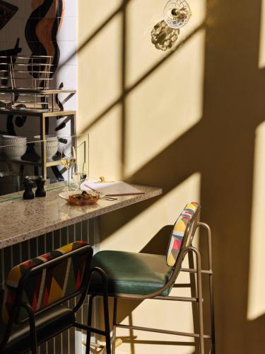 a kitchen with two chairs and a counter at The Hoxton, Lloyd Amsterdam in Amsterdam