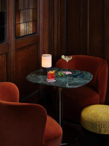 a table in a room with two chairs and a wine glass at The Hoxton, Lloyd Amsterdam in Amsterdam