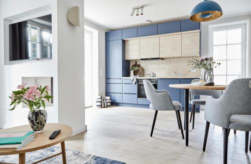 uma cozinha com armários azuis e uma mesa e cadeiras em Strandglück Prerow em Prerow