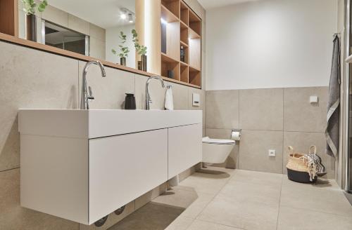 a white bathroom with a sink and a toilet at Strandglück Prerow in Prerow