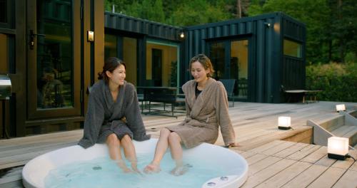 two women sitting on a surfboard in a hot tub at 郷音 ～G.O.A.T～ in Tsuru 