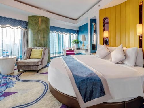 a hotel room with a large bed and a chair at Days Hotel & Suites China Town---Five minutes to reach Changsha Station, the metro Line 2 & Line 6 are nearby,free gym & laundromat,Chinese and Western buffet breakfast is offered on the 31st floor in Changsha
