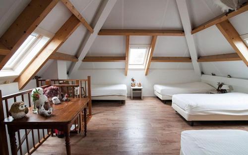 a attic room with two beds and a table at Farm Overleekerhoeve in Monnickendam