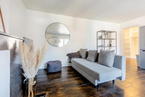 a living room with a couch and a mirror at L'appartement Casquette in Liège