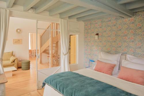- une chambre avec un lit et un mur orné de papier peint floral dans l'établissement Magnifique maison proche de Paris, La Prairie by Oasis House, à Égreville