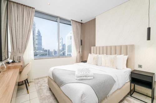 a bedroom with a large bed with a large window at Nasma Luxury Stays - Elegant 1BR With Stunning View of Park Avenue in Dubai