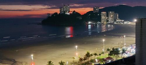 a view of a beach at night with a city at Apartamento kitnet frente ao mar in São Vicente