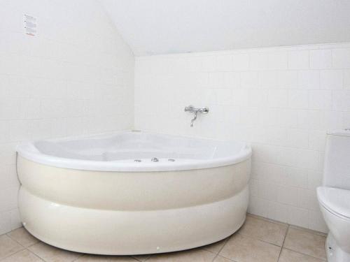 a white bath tub in a bathroom with a toilet at 8 person holiday home in Gjern in Gjern