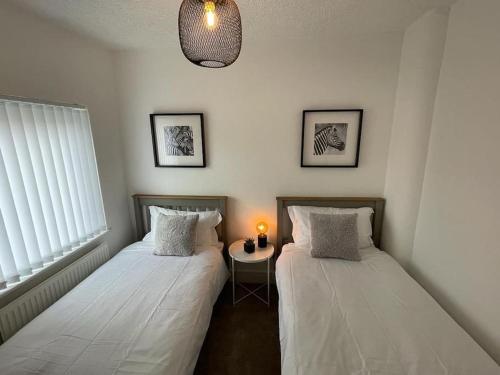 two beds sitting next to each other in a room at Charming Terrace Home, Nantwich -Near train station & Town in Nantwich