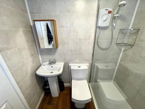 a bathroom with a toilet and a sink and a shower at Terrace House - Charming home near town and train station in Nantwich