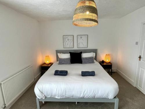 a bedroom with a bed with two blue towels on it at Terrace House - Charming home near town and train station in Nantwich